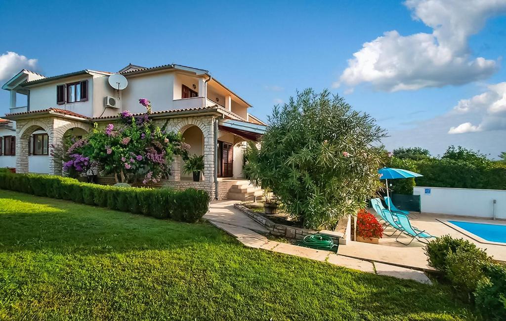 a house with a swimming pool in a yard at Stunning Home In Pula With 4 Bedrooms, Wifi And Outdoor Swimming Pool in Premantura