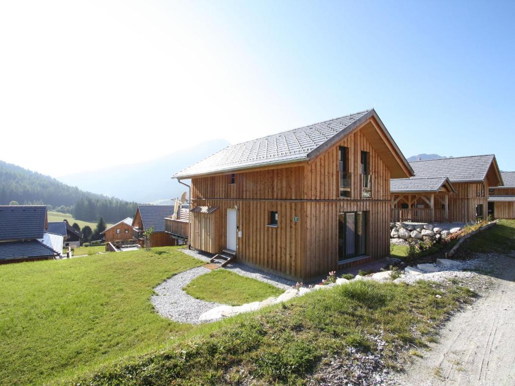 uma casa de madeira numa colina com um campo de relva em Wooden chalet in Hohentauern Styria with sauna em Hohentauern