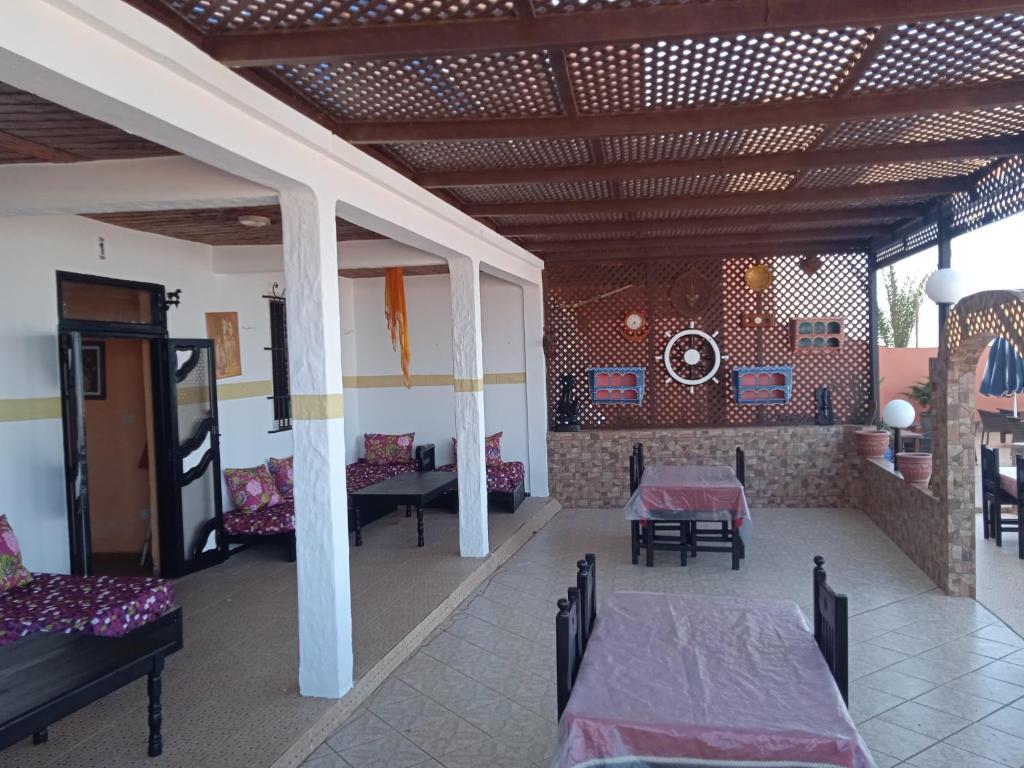 una camera con due letti e sedie e una stanza con una parete di Auberge Sable D'Or a Sidi Ifni