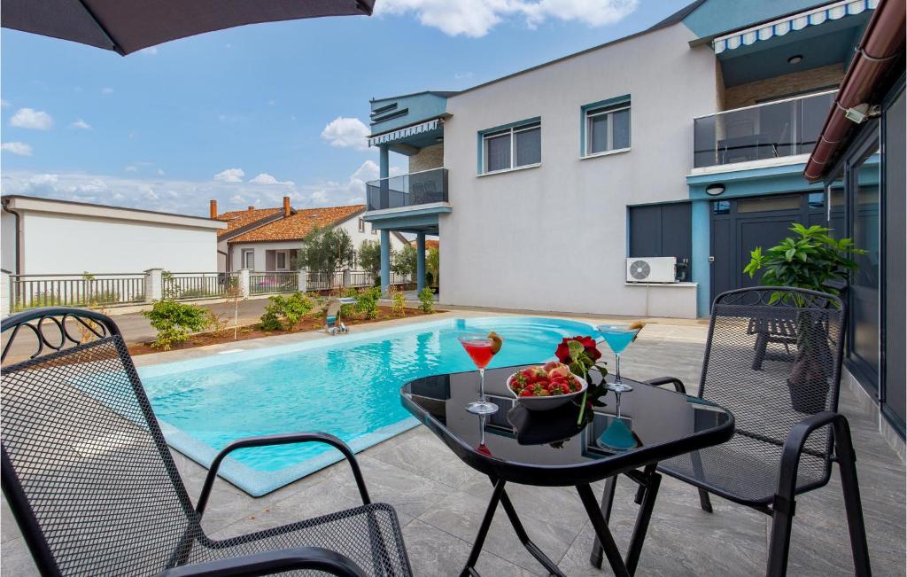 un patio con mesa y sillas junto a una piscina en Nice Apartment In Vrh With 1 Bedrooms, Wifi And Outdoor Swimming Pool en Vrh
