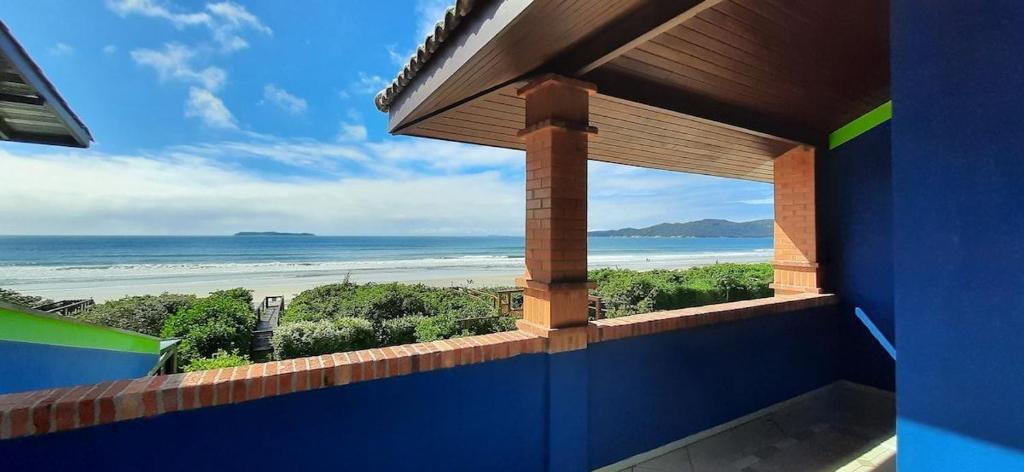 uma vista para a praia a partir de uma varanda da casa em Casa TOP, 3 Suítes, Acesso Privativo a Praia do Mariscal em Bombinhas