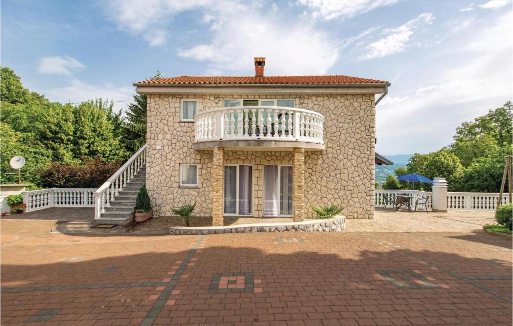a large stone house with a white balcony at Nice Apartment In Matulji With Kitchen in Matulji