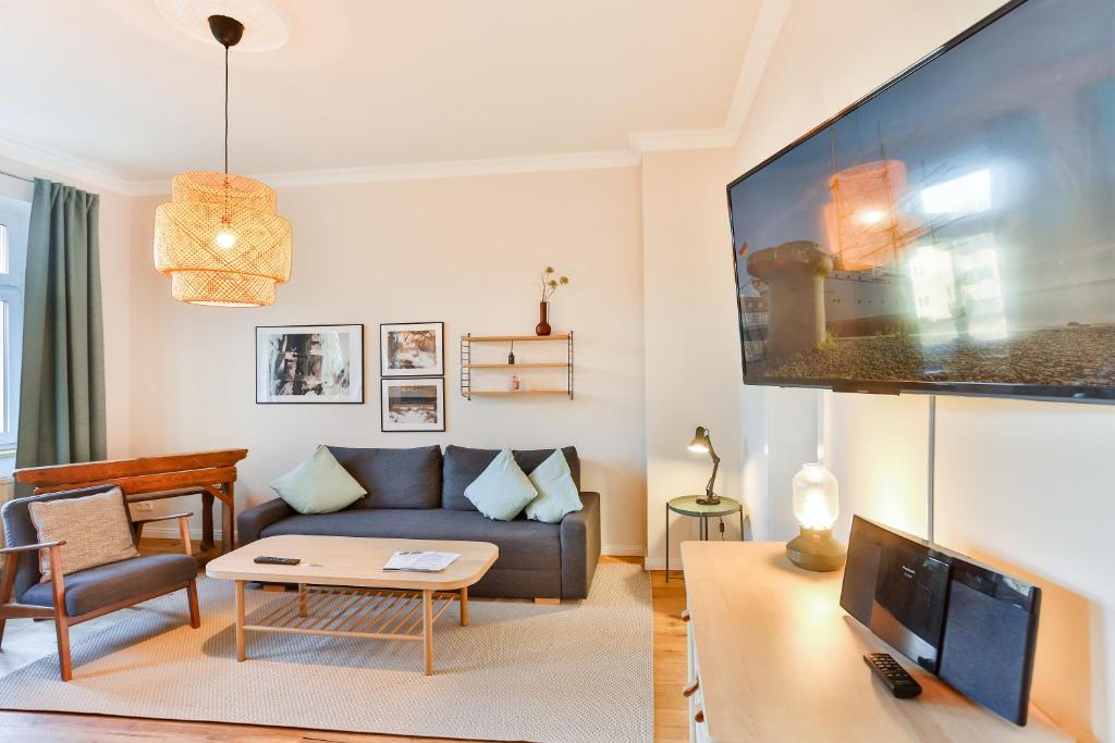 een woonkamer met een bank en een tv bij Ferienwohnung an der Brunnenaue in Stralsund