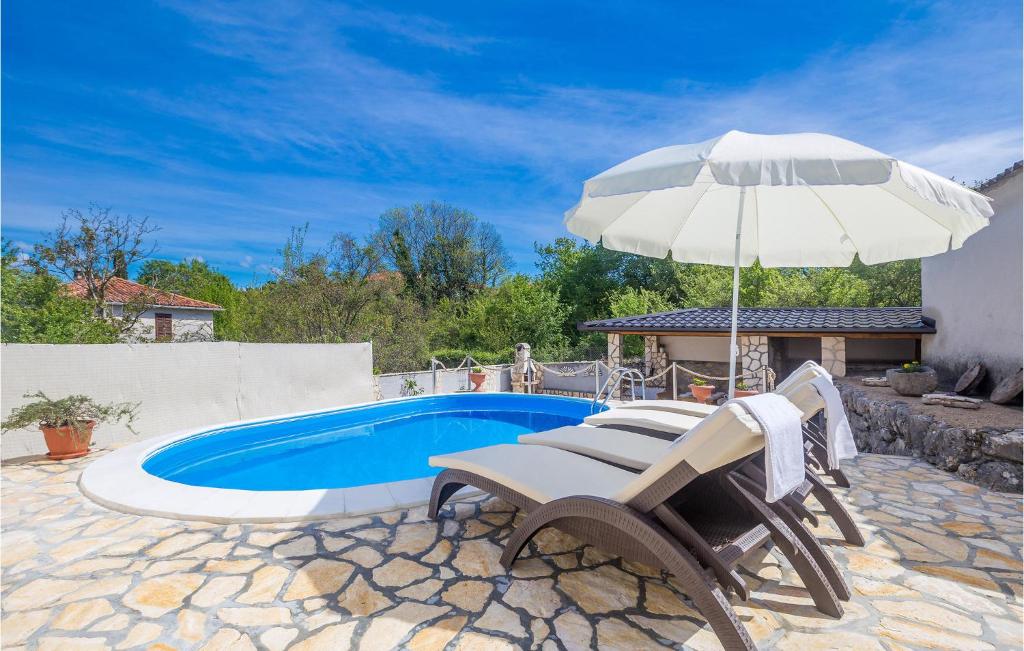 una piscina con due sedie e un ombrellone e un tavolo e sidx sidx di Pet Friendly Home In Sveti Vid With Outdoor Swimming Pool a Sveti Vid-Miholjice
