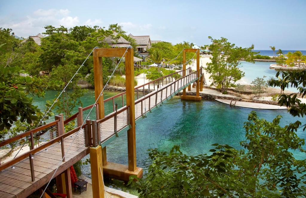 un puente colgante sobre un río con agua azul en GoldenEye, en Oracabessa