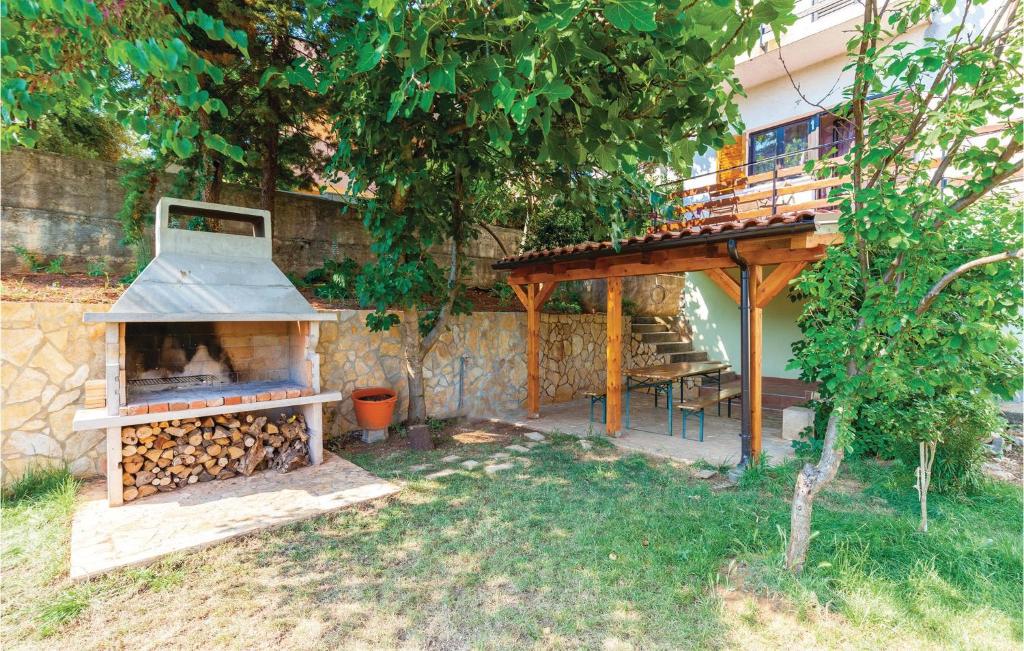 a outdoor grill with a pile of fire wood at Gorgeous Apartment In Krk With Kitchen in Krk