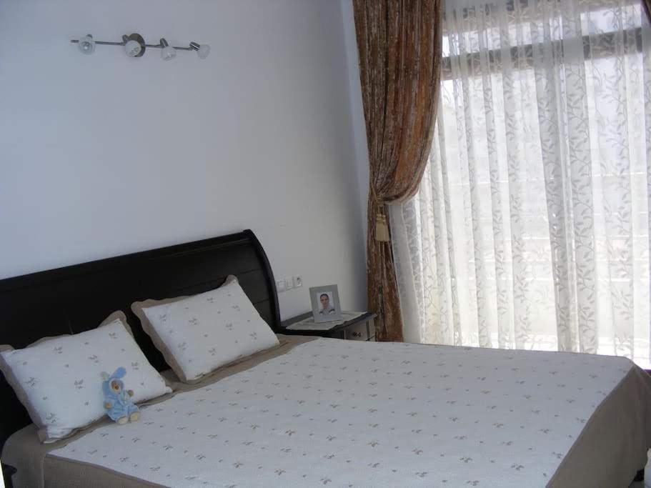 a bedroom with a bed with a large window at Appartement Hamria Meknes in Meknès