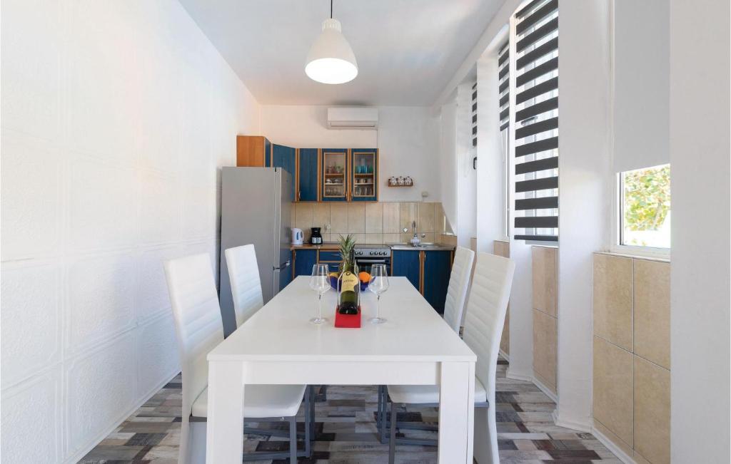 a white dining room table with white chairs in a kitchen at Awesome Apartment In Zadar With Wifi in Zadar