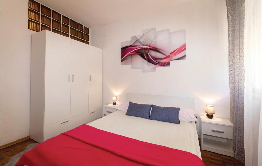 a bedroom with a bed and a painting on the wall at Awesome Apartment In Zadar With Wifi in Zadar