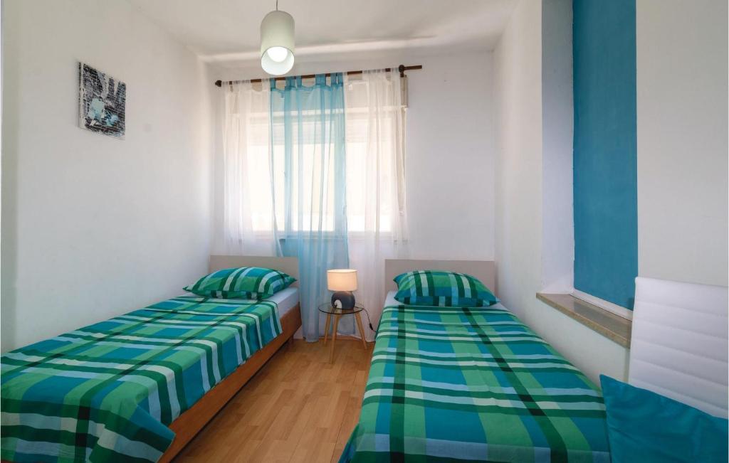 two beds sitting in a room with a window at Awesome Apartment In Zadar With Wifi in Zadar