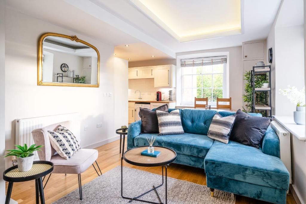 a living room with a blue couch and a table at Stunning 2 Bedroom Apartment in Converted Chapel in Bath