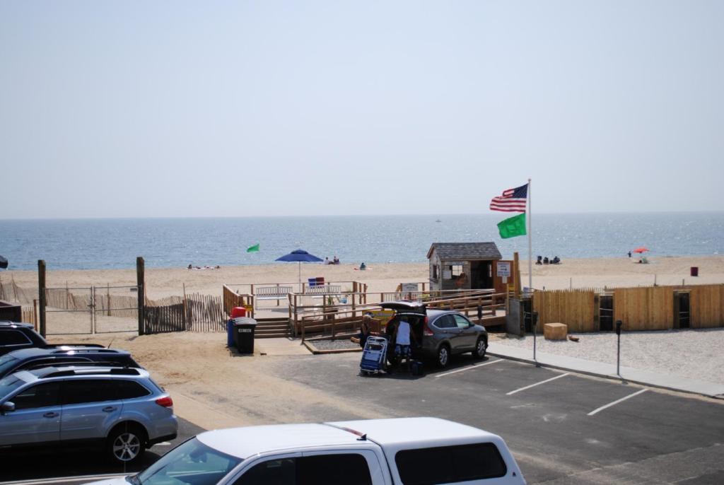 een parkeerplaats naast een strand met auto's geparkeerd bij Windswept Motel in Point Pleasant Beach