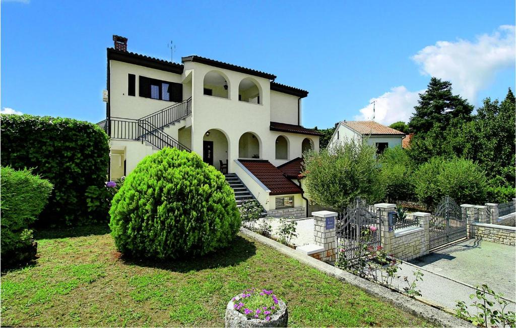 a large white house with a landscaped yard at Beautiful Apartment In Porec With Kitchen in Poreč