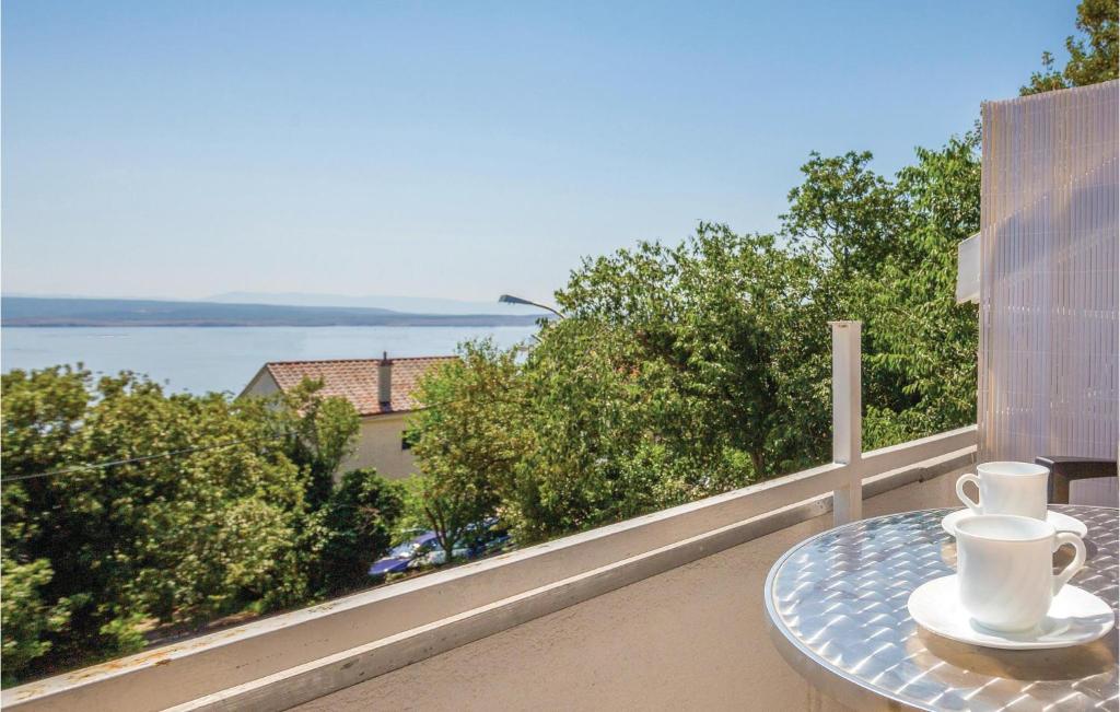 una mesa en un balcón con vistas al agua en Gorgeous Apartment In Dramalj With Kitchen en Dramalj