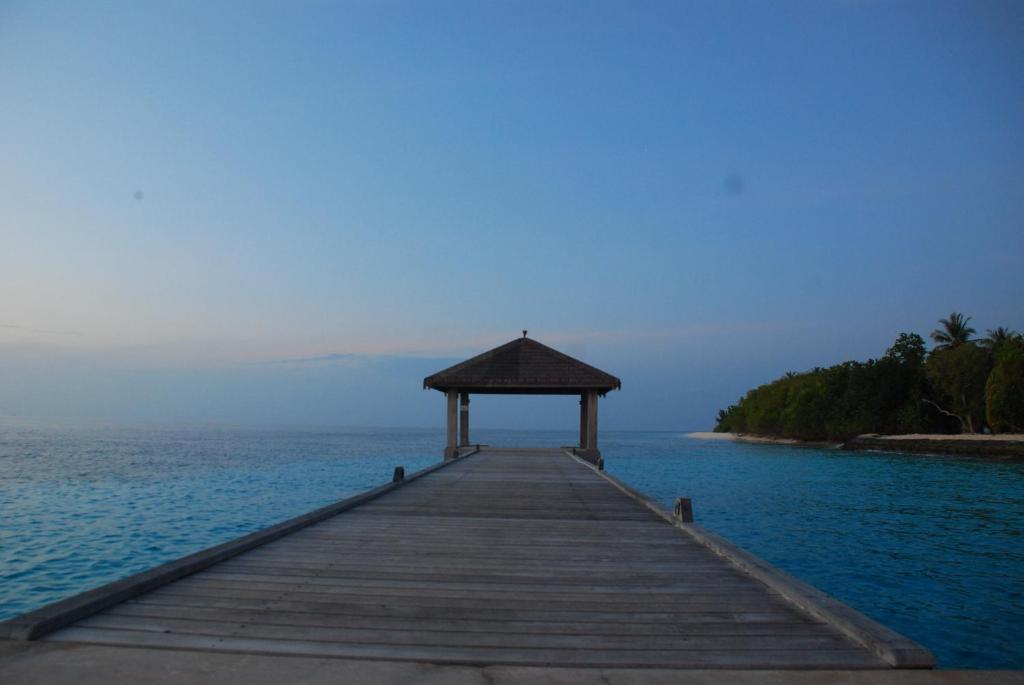 a wooden pier with a gazebo on the water at PRIV Fodhdhoo in Fodhdhoo