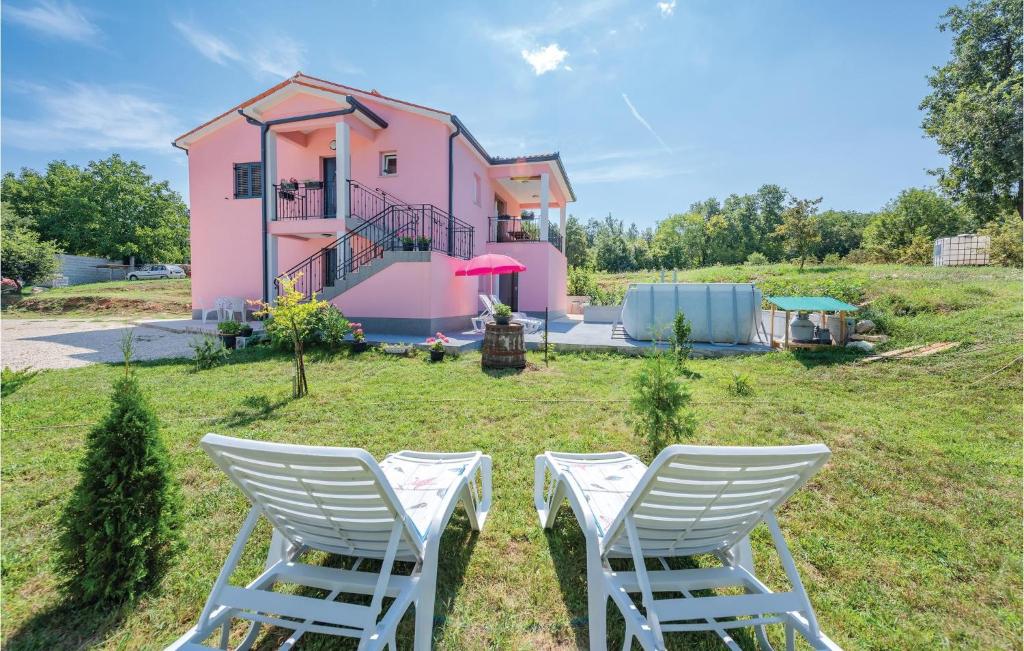 a pair of chairs in front of a pink house at Nice Apartment In Boljevici With Wifi in Kršan