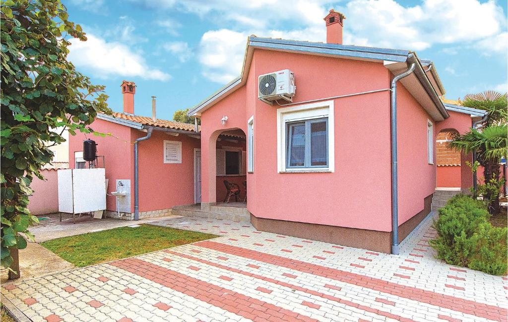 una casa rosa con en Stunning Home In Betiga With Kitchen, en Barbariga