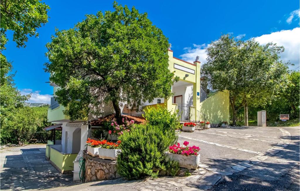 un edificio con flores y un árbol en una calle en Stunning Apartment In Klenovica With Wifi, en Klenovica