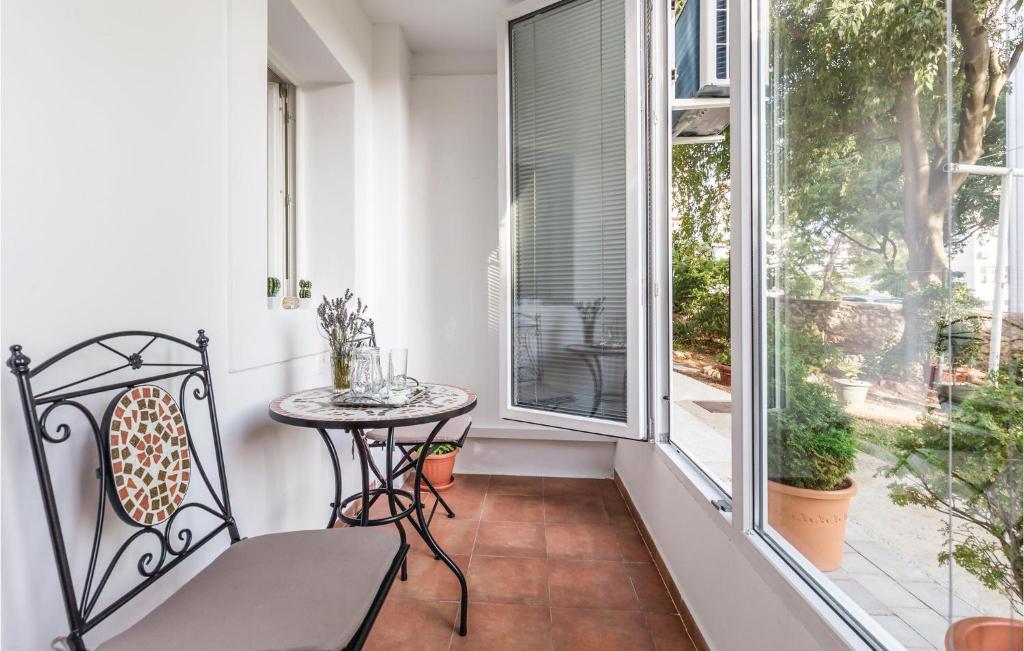 Elle comprend un petit balcon avec une table et une fenêtre. dans l'établissement 1 Bedroom Gorgeous Apartment In Rijeka, à Rijeka