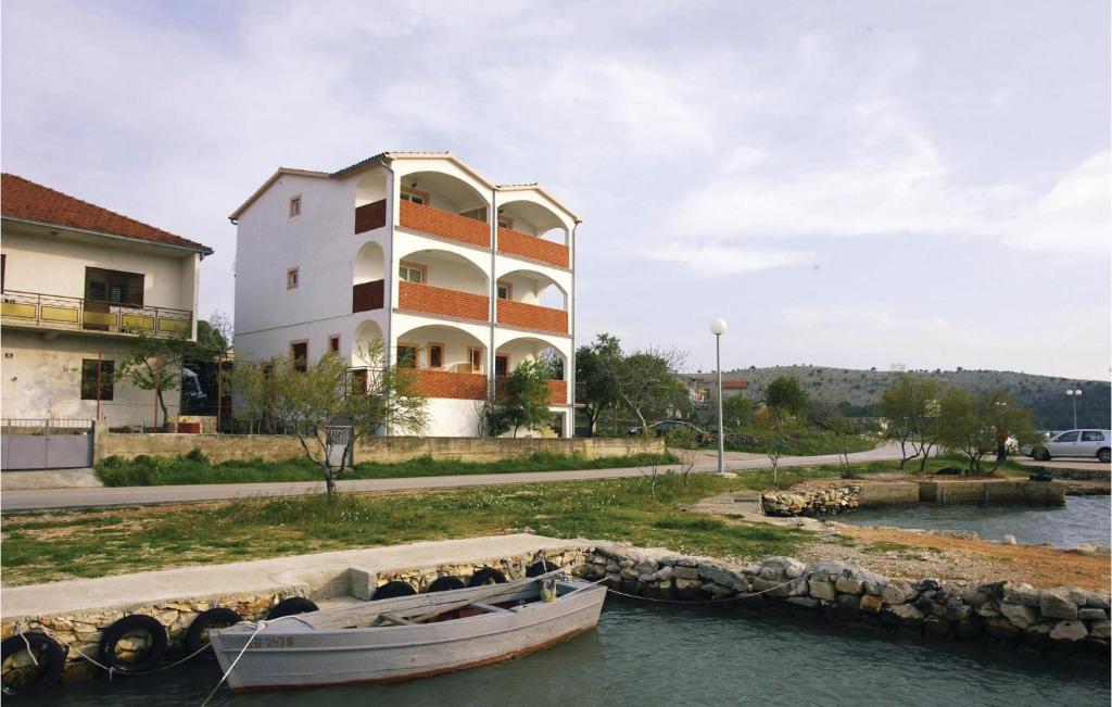 a boat in the water in front of a building at Awesome Apartment In Jadrtovac With 1 Bedrooms in Jadrtovac