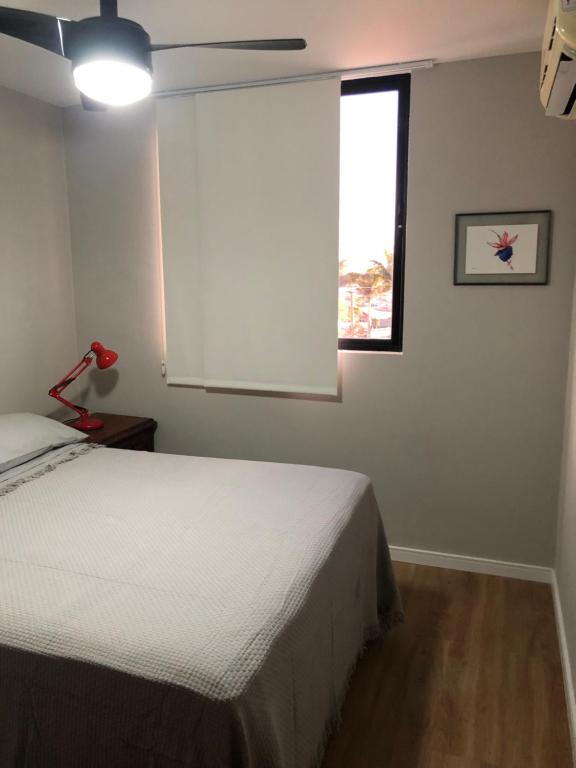 Schlafzimmer mit einem Bett und einem Fenster in der Unterkunft Apartamento na Prata in Campina Grande
