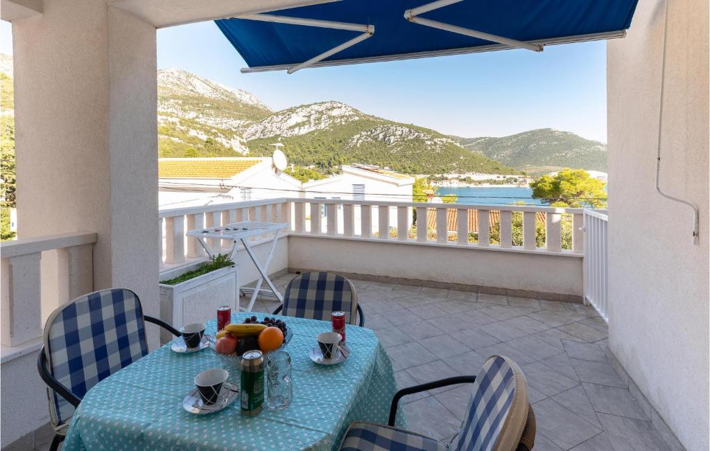 a table and chairs on a balcony with mountains at Two-Bedroom Apartment In Klek in Klek