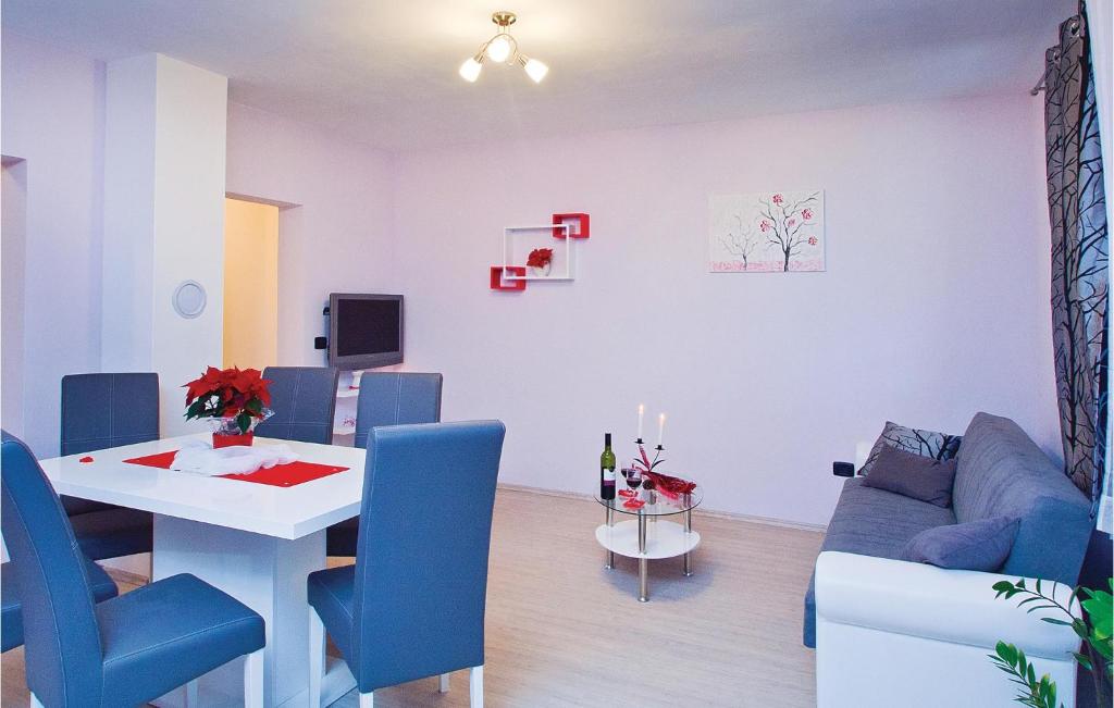salon ze stołem i niebieską kanapą w obiekcie Apartment Orbanici 03 w mieście Orbanići