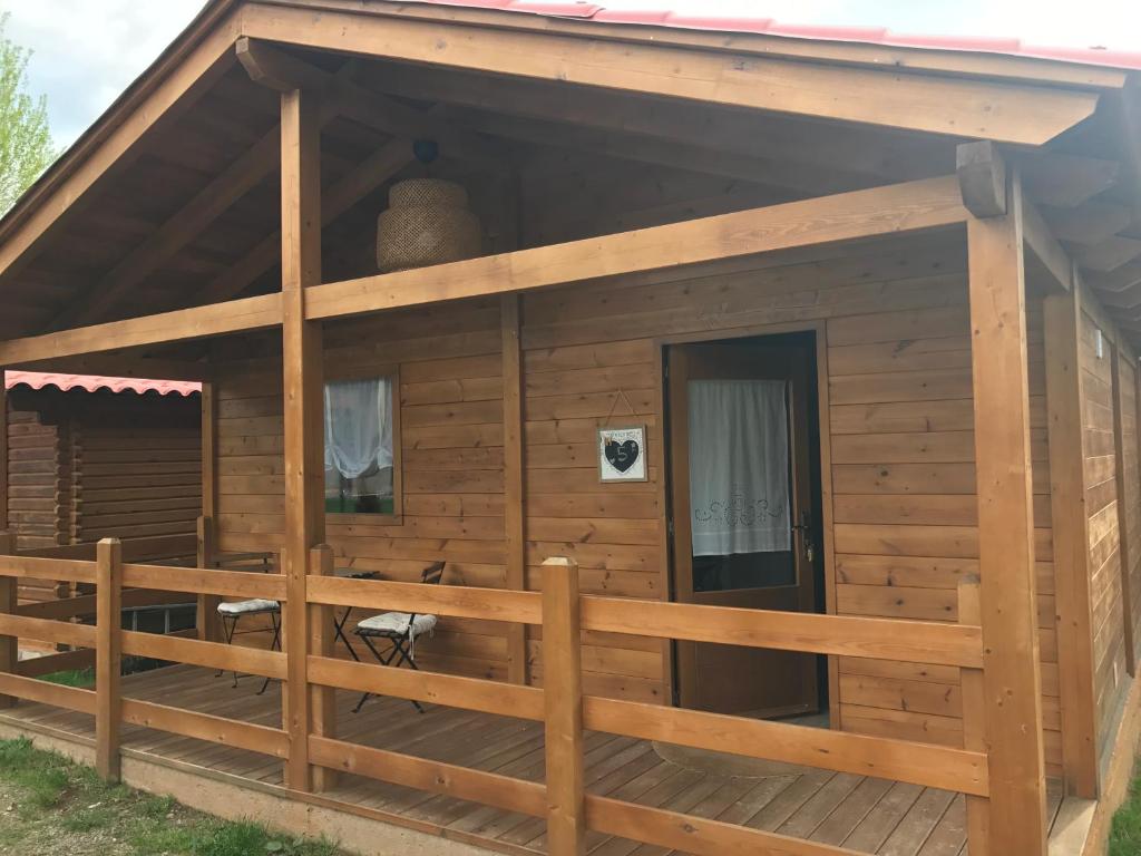 una grande cabina in legno con una recinzione intorno di CAMPING PUIGCERCOS a Borredá