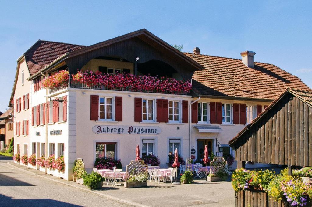 Un bâtiment avec des fleurs en haut dans l'établissement Auberge et Hostellerie Paysanne, à Lutter