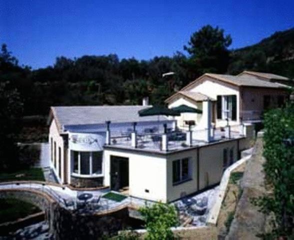 a large white house with a bridge in front of it at Hotel Il Saraceno in Volastra