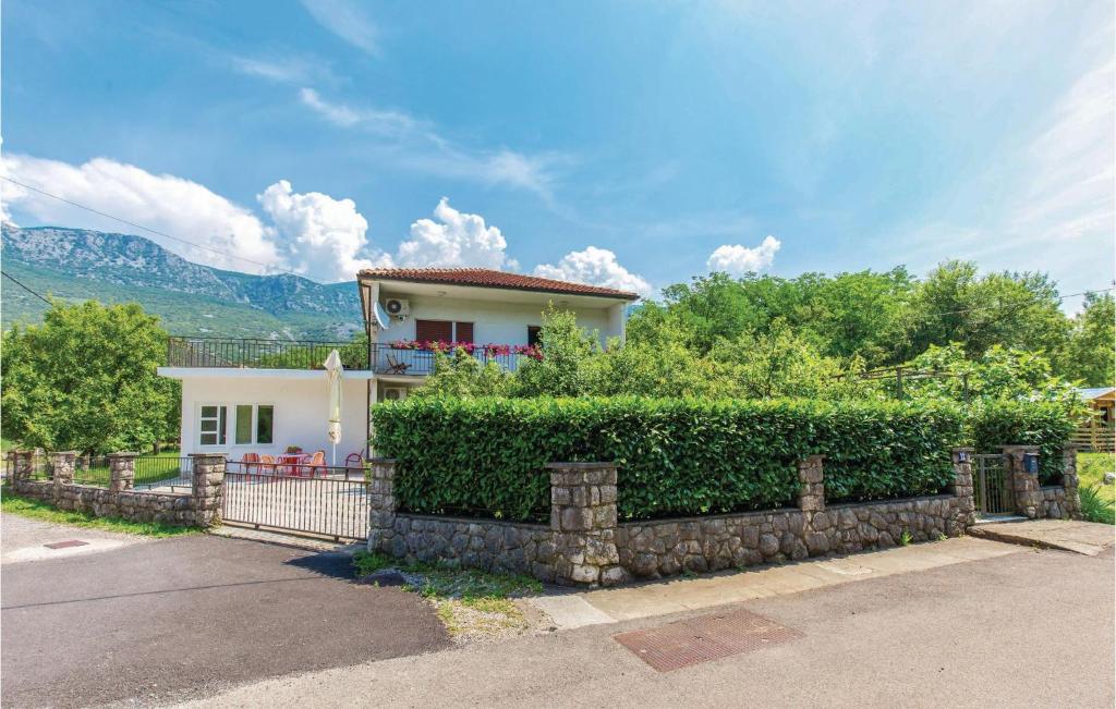 a white house with a fence in front of it at Stunning Apartment In Tribalj With Kitchen in Tribalj