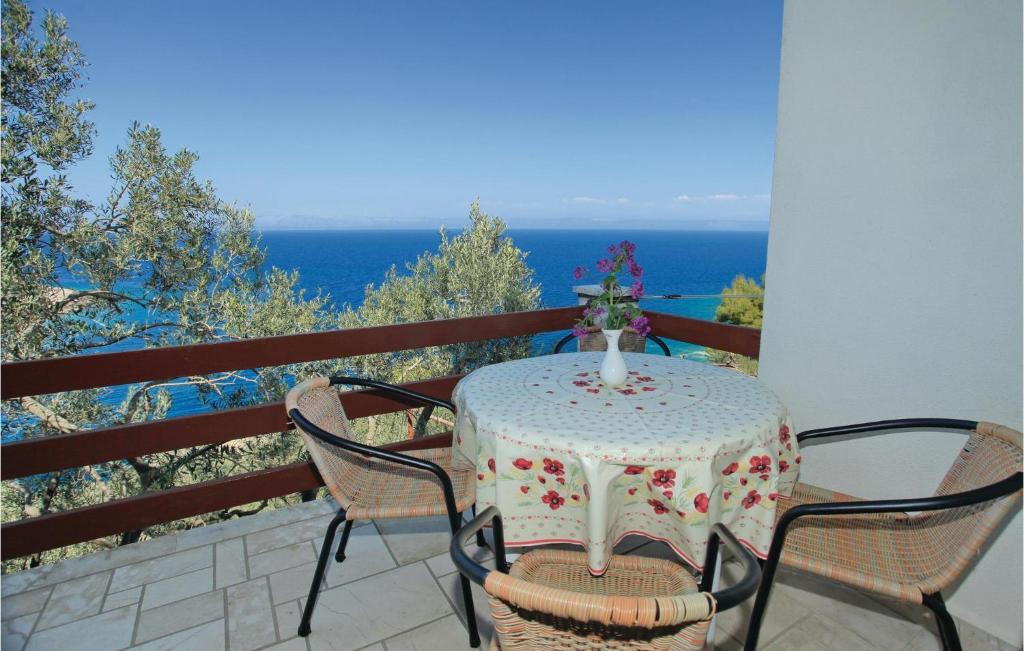 una mesa y sillas en un balcón con vistas al océano en Amazing Apartment In Blato With Kitchen, en Blato