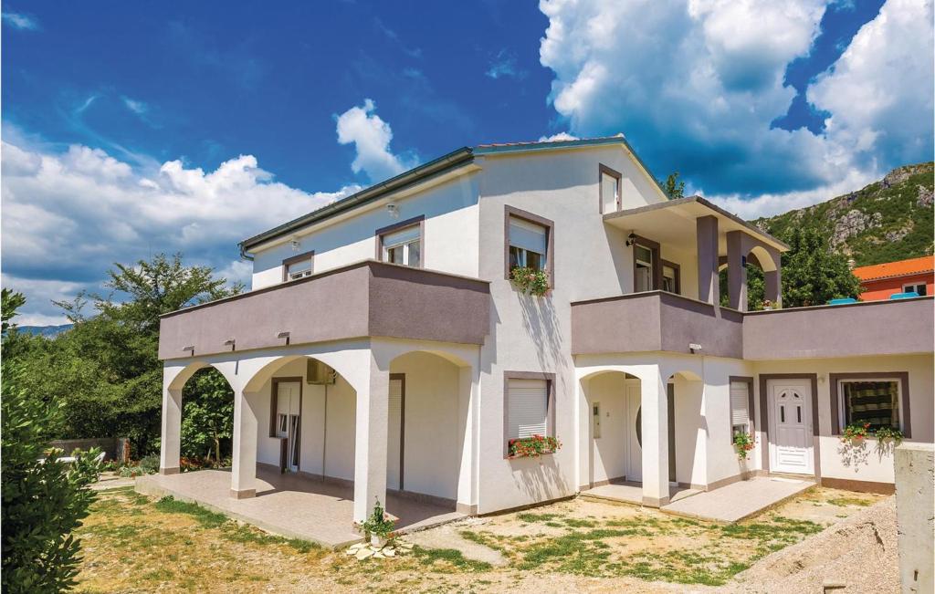 a large white house with arches on a yard at 2 Bedroom Awesome Apartment In Grizane in Grižane