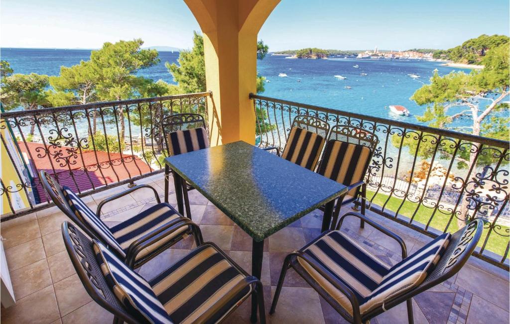 un tavolo e sedie su un balcone con vista sull'oceano di Pet Friendly Apartment In Banjol With Kitchen a Banjol