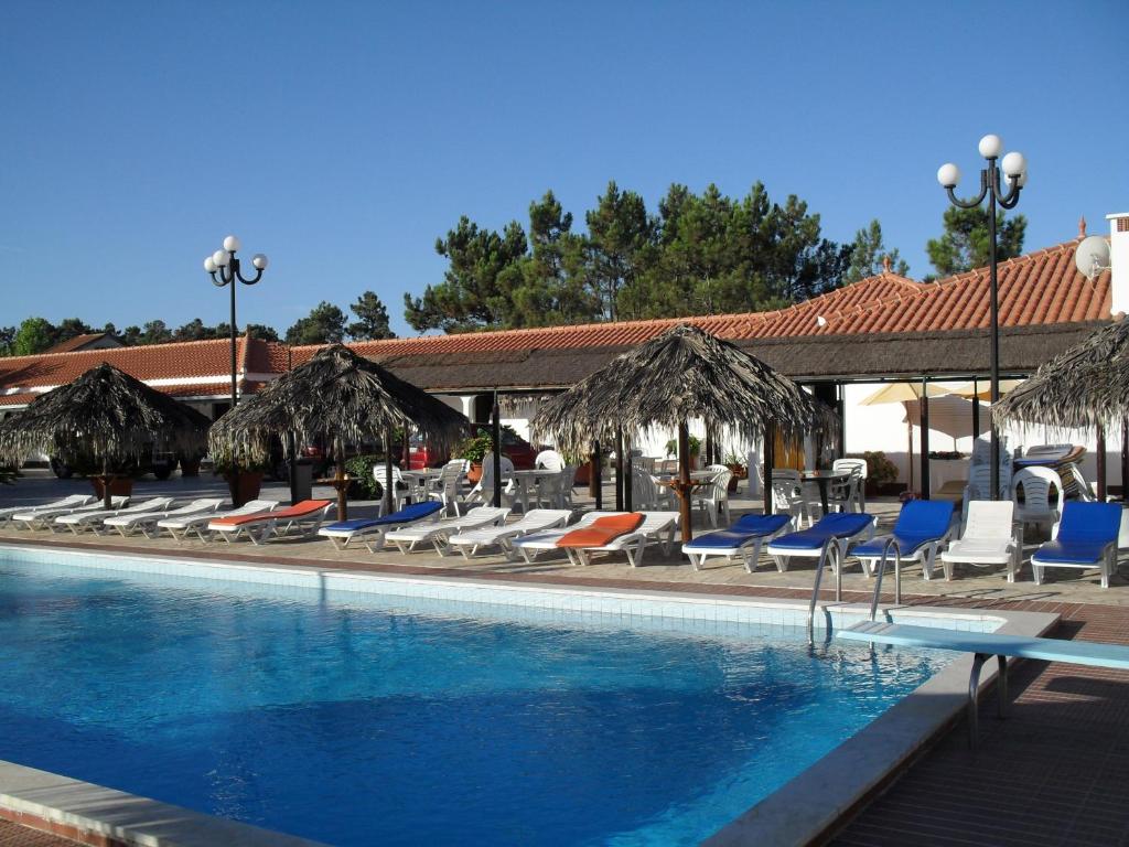una piscina con tumbonas y una piscina en Lobateira Villas en Fernao Ferro