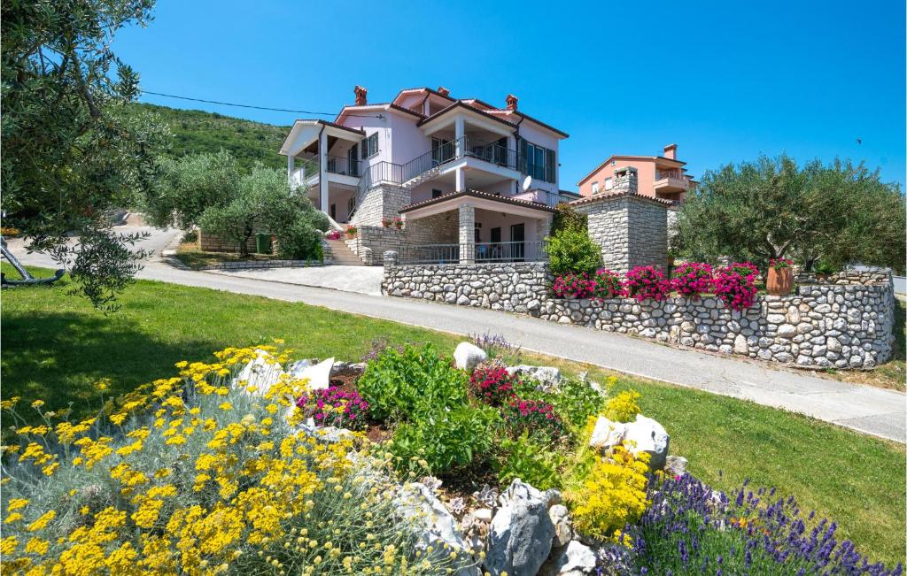 a house on a hill with flowers in the yard at Amazing Apartment In Ravni With House Sea View in Ravni