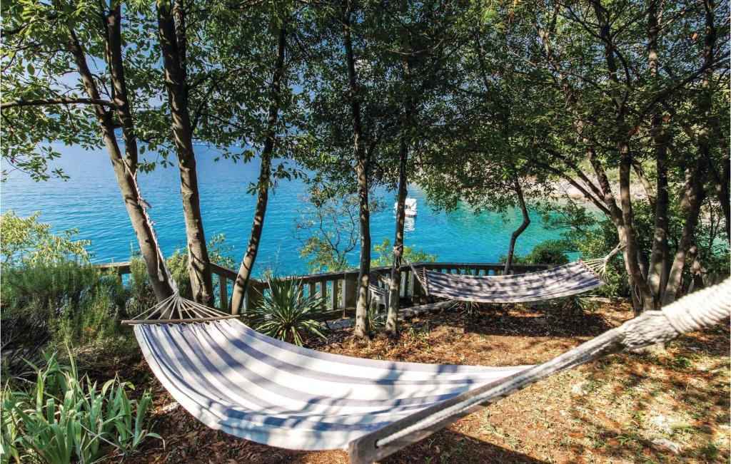 two hammocks sitting in the trees near the water at Gorgeous Apartment In Rijeka With House Sea View in Rijeka