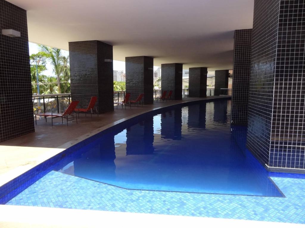a swimming pool with blue water in a building at Flat Mar Vip in Fortaleza