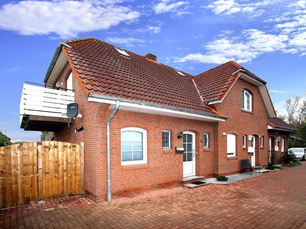 a red brick house with a brown roof at Semi-detached house Schwittersum, Dornum in Dornum