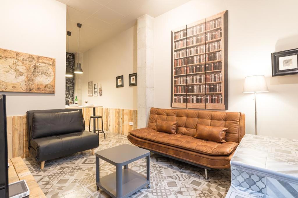 sala de estar con sofá de cuero y silla en HISTORICAL CENTER OLLERIAS en Málaga