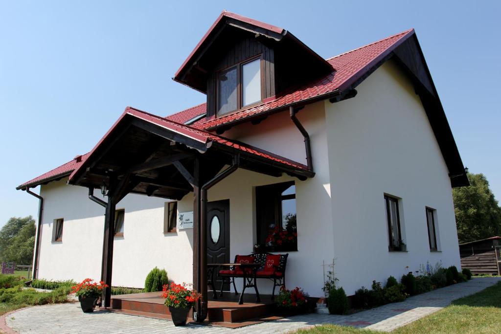 un cottage con tetto rosso di Ośrodek Wypoczynkowo Sportowy Pod Żurawiem a Lniano