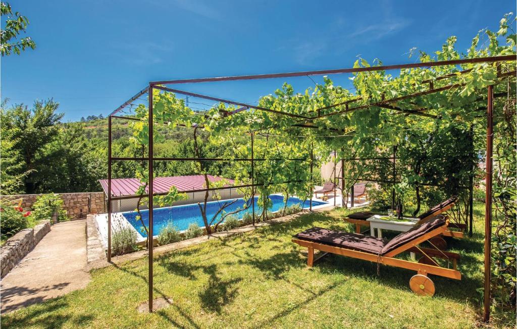 a garden with a pergola and a swimming pool at Awesome Home In Krizisce With Kitchen in Križišće