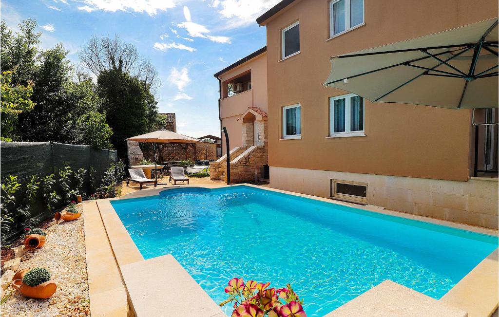 uma piscina em frente a uma casa com um guarda-chuva em 6 Bedroom Nice Home In Babici em Babići