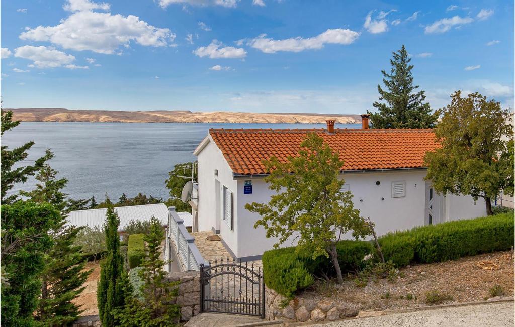 a white house with an orange roof next to the water at Beautiful Apartment In Baric Draga With House Sea View in Barić Draga