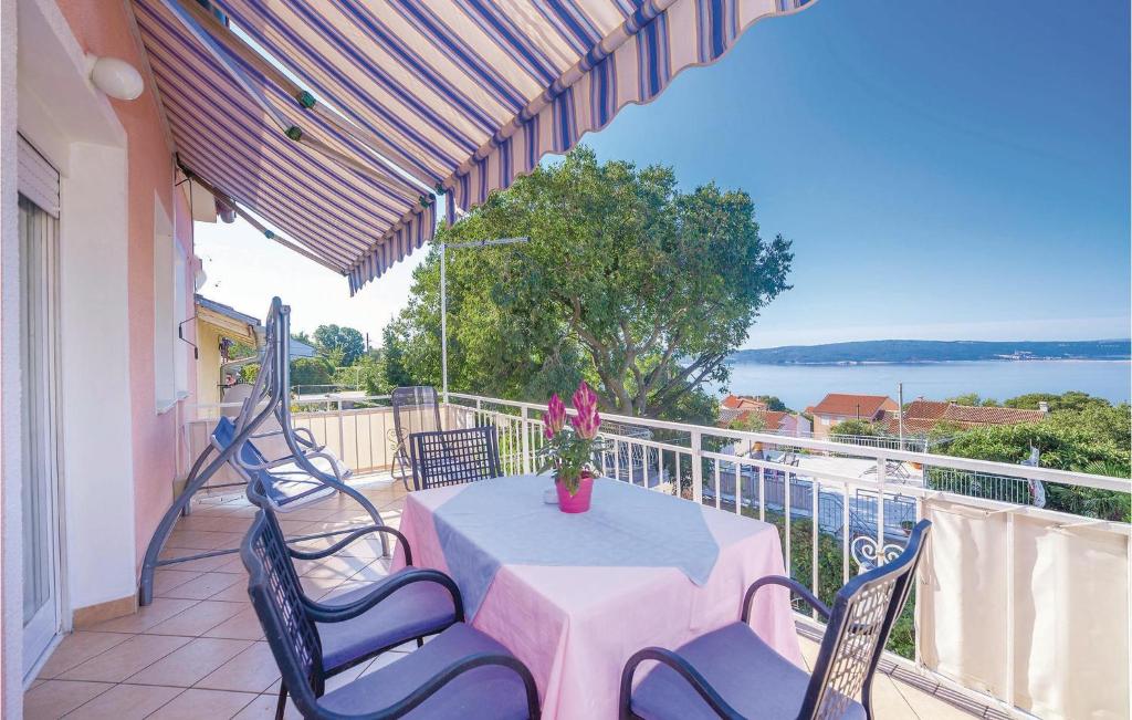 a patio with a table and chairs on a balcony at Pet Friendly Apartment In Dramalj With House Sea View in Dramalj