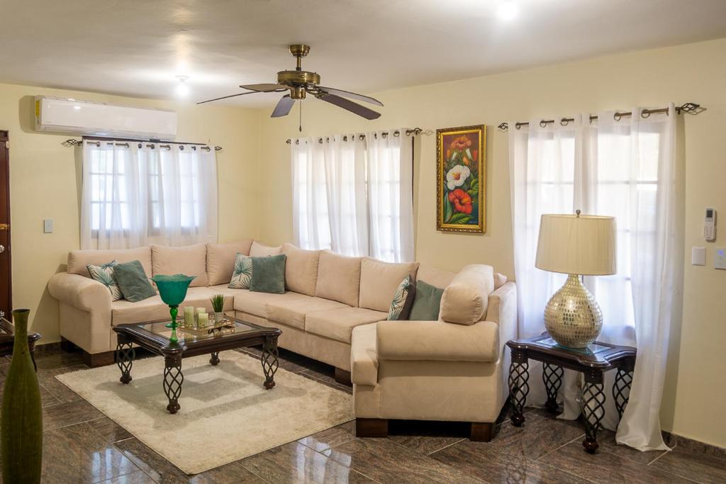 a living room with a couch and chairs and a ceiling fan at Hospedaje de Marant in San Felipe de Puerto Plata