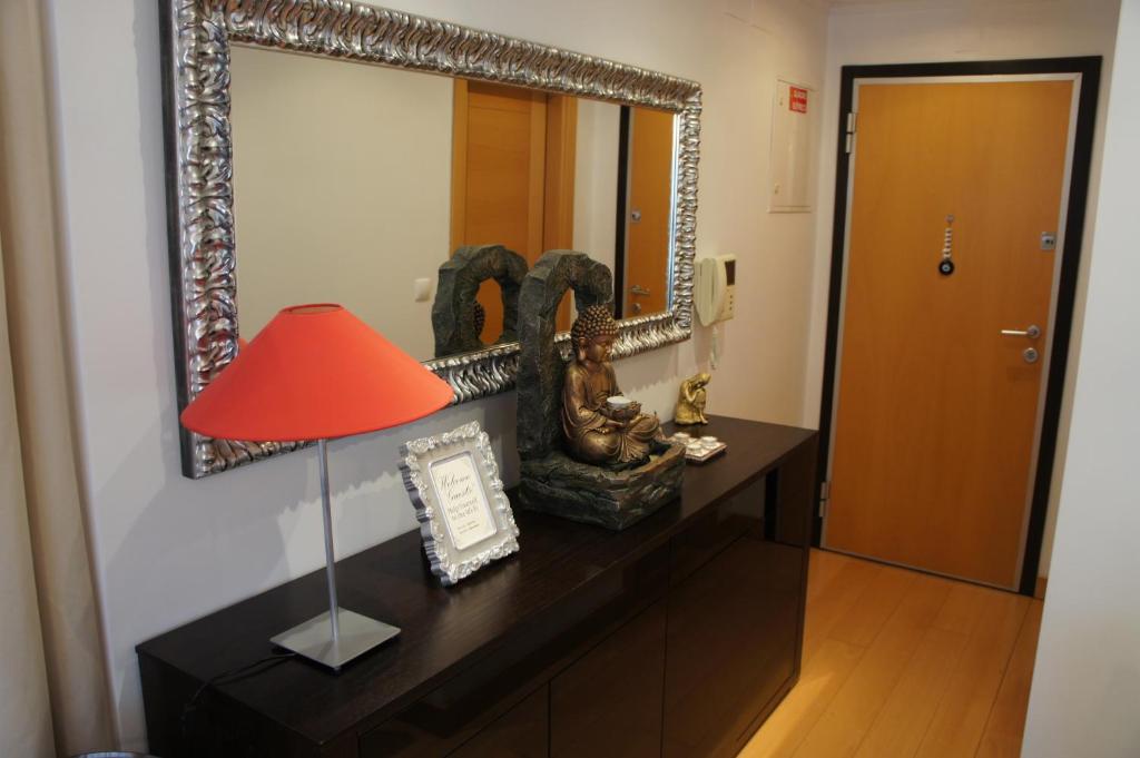 une chambre avec un miroir et une lampe sur une commode dans l'établissement Apartamento Zen em pleno centro de Lisboa, à Lisbonne