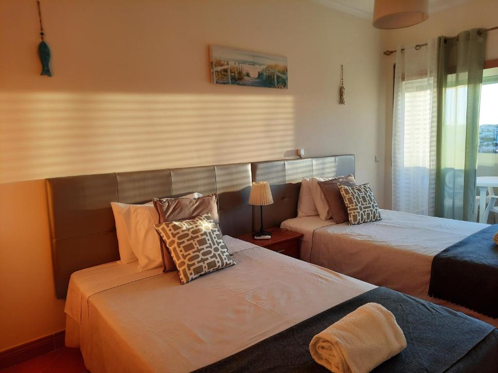 ein Schlafzimmer mit 2 Betten mit Kissen darauf in der Unterkunft Summer Dream - Meia Praia Beach in Lagos