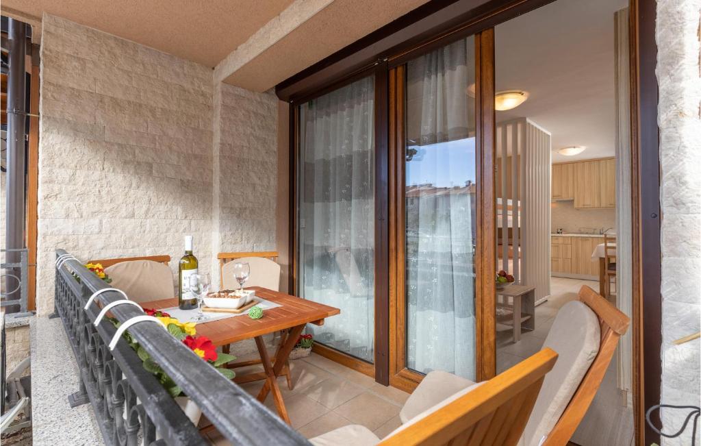 een patio met een houten tafel en stoelen op een balkon bij Cozy Apartment In Crikvenica With Kitchen in Crikvenica