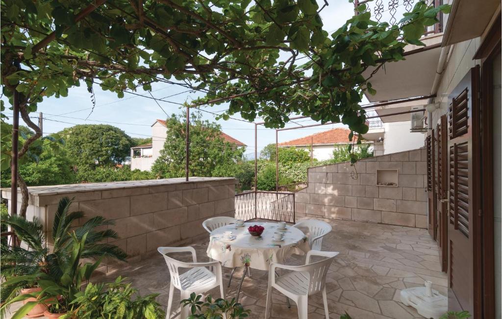 a patio with a white table and chairs at Stunning Apartment In Supetar With 2 Bedrooms And Wifi in Supetar